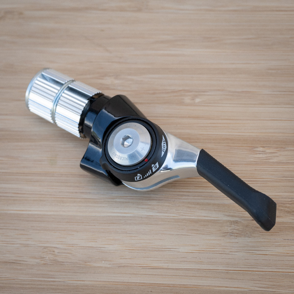 The RBW means it's our, and nobody else can get it unless we say so.This lever is set on 9sp index. The 4mm hex hole is a tension bolt. Loosen a bit and use the bump (at about 8:00 in this photo) to push the red do to F/friction...if you want friction shifting.